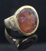 An antique gold mounted Roman? intaglio carnelian ring, of oval shape, caved with two figures (