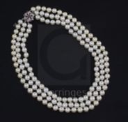 A three-strand uniform cultured pearl necklace with ruby, diamond and white gold (tests as 9ct)