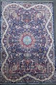 A Tabriz blue ground carpet, with field of scrolling geometric motifs and wavy border,