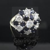 A diamond and sapphire cluster ring, set with seven brilliant cut diamonds and twelve sapphires,