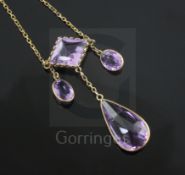 An early 20th century gold and shaped cut amethyst drop necklace, set with four stones, largest pear