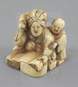 An ivory netsuke of a woman and child, 19th century, kneeling before a large stone, beating cloth,