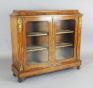 A Victorian marquetry inlaid burr walnut bookcase, with ormolu mounts and two glazed doors enclosing