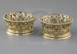 A pair of George V silver gilt bottle coasters by Pairpoint Brothers, of flared form, with pierced