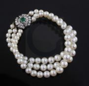 A French triple strand graduated cultured pearl bracelet with 18ct gold and platinum, emerald and
