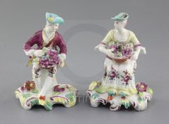 A near pair of Derby seated figures of fruit sellers, c.1759-60, each holding a basket of fruit,