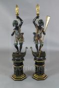 A pair of Venetian carved and painted wood blackamoors, each standing upon the prow of a gondola,