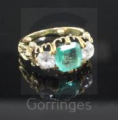 A late Victorian emerald and diamond three stone ring, with ornate pierced carved shoulders, size