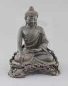 A Chinese bronze seated figure of Buddha Shakyamuni, 18th/19th century, on a contemporary hardwood