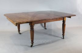 A large George IV mahogany extending dining table, the rounded rectangular top with six leaves, on