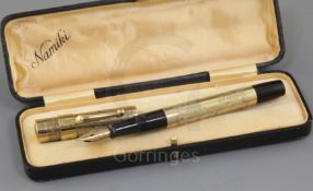 A cased Namiki 14k rolled gold fountain pen, with foliate engraved barrel stamped 'Namiki Made in