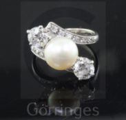 A white gold, natural pearl and two stone diamond crossover ring, with diamond set shoulders and