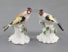 A near pair of Derby figures of goldfinches, c.1765-70, each perched on a flower encrusted tree