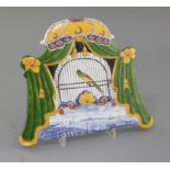 A Dutch Delft polychrome trompe-l'oeil 'bird' plaque, first half 19th century, depicting a bird in a