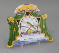 A Dutch Delft polychrome trompe-l'oeil 'bird' plaque, first half 19th century, depicting a bird in a