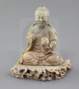 A Chinese soapstone figure of a Luohan, 18th century, the figure seated holding a begging bowl,