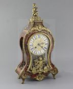 An early 20th century ormolu and red boulle Louis XVI style mantel clock, with enamelled tablet