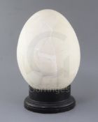 A reconstructed Elephant Bird egg, approximately 31cm, with ebonised wood stand