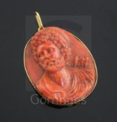 An antique Italian gold mounted oval coral cameo pendant, carved with the bust of a bearded