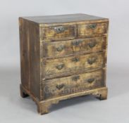 A George III feather banded fruitwood chest of two short and three graduated long drawers, on