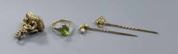 A 15ct gold and single stone peridot ring, two yellow metal and gem set stick pins and a gold plated