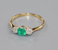 A yellow metal, emerald and diamond three stone ring, size N.