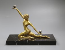 An Art Deco model of a ball acrobat/dancer, guilded bronze, on black marble base 22cm high