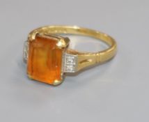 An 18ct gold and citrine ring with diamond set shoulders, size M/N.