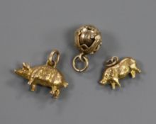 A yellow metal masonic ball pendant opening to form a cross and two yellow metal pig charms, one