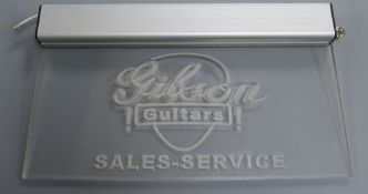 A Gibson guitars sales and service light up sign