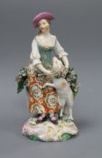 A Derby figure of a shepherdess, c.1765, standing before bocage, holding a garland of flowers around