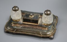 An early 20th century plated inkstand with two mounted glass wells and central lidded compartment