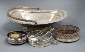 A George III silver wine coaster, London, 1768, two later silver coasters, a photo frame, tongs,