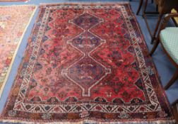 A Caucasian red and blue medallion rug, with triple geometric border, worn in places, 240 x 180cm