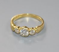 A modern 18ct gold and three stone collet set diamond ring, size N.