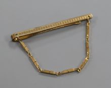 A 9ct. gold tie clip with chain.