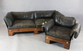 A 1960s Norwegian rosewood veneered sofa and armchair ensuite, with black leather covered feather