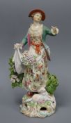 A Derby figure of a Shepherdess, c.1765-70, standing before bocage, with an apron of flowers and a
