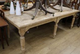 A stripped pine farmhouse kitchen table, raised on six turned legs W.244cm