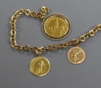 A yellow metal bracelet hung with two 18ct gold charms and a mounted gold medallion.