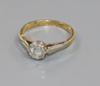 An early 20th century 18ct gold, platinum and illusion set solitaire diamond ring, size J/K.