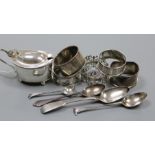 A silver mustard, five silver napkin rings and three silver teaspoons.