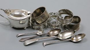 A silver mustard, five silver napkin rings and three silver teaspoons.