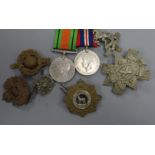 Two WWII service medals and six cap/tunic badges