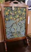 An Edwardian inlaid mahogany firescreen inset woolwork panel in a William Morris-style bird and