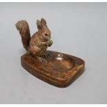 A cold-painted bronze model of a squirrel mounted on a brown onyx ashtray, the squirrel sitting