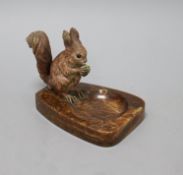 A cold-painted bronze model of a squirrel mounted on a brown onyx ashtray, the squirrel sitting