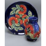 A Moorcroft Sally Tuffin Pohutukawa pattern vase, H 13cm and a trial plate in the same design, 1992