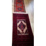 Two red ground rugs 144 x 78cm and 117 x 62cm