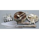 A modern silver wine coaster, a silver toastrack, an Egyptian white metal dish and seven items of